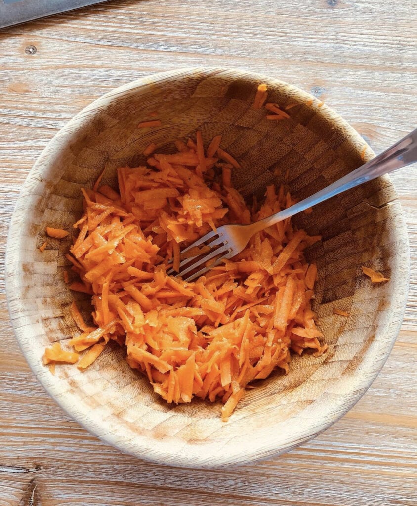 making Carottes Rapées with the best carrot shredder in a wooden bowl