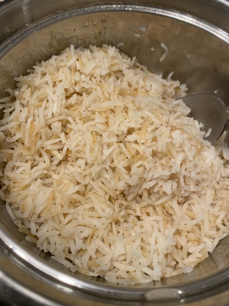 Saute Rice Before Cooking - basmati rice completely cooked in a stainless steel rice cooker.