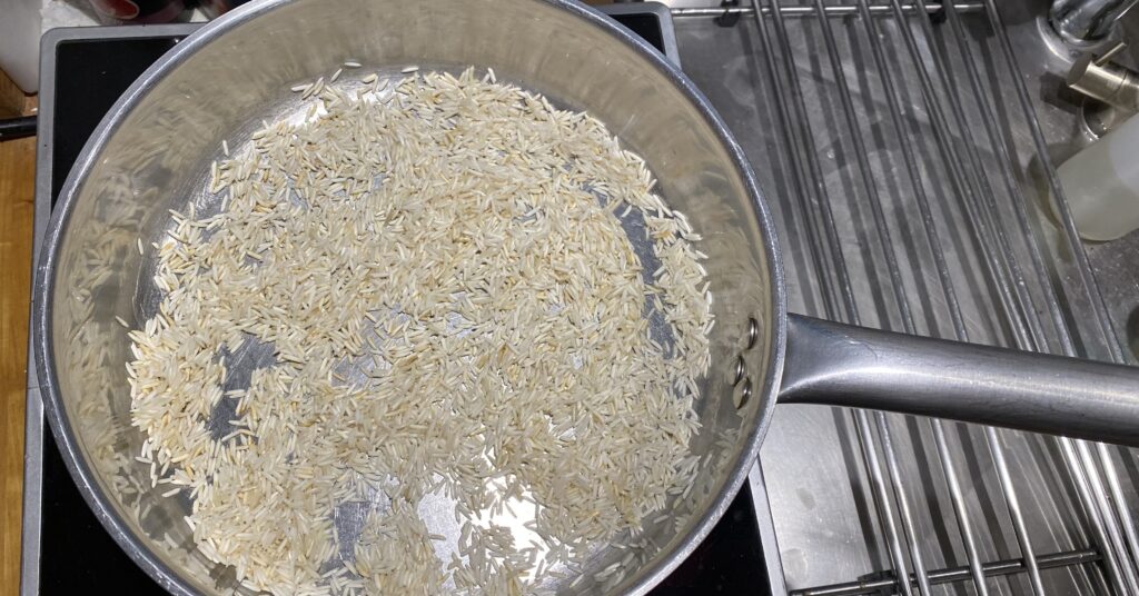 basmati rice that is toasting in a stainless steel pot
